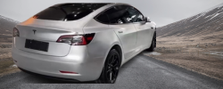 A clean, finished car with a silver matte wrap parked under sunlight reflecting its subtle texture